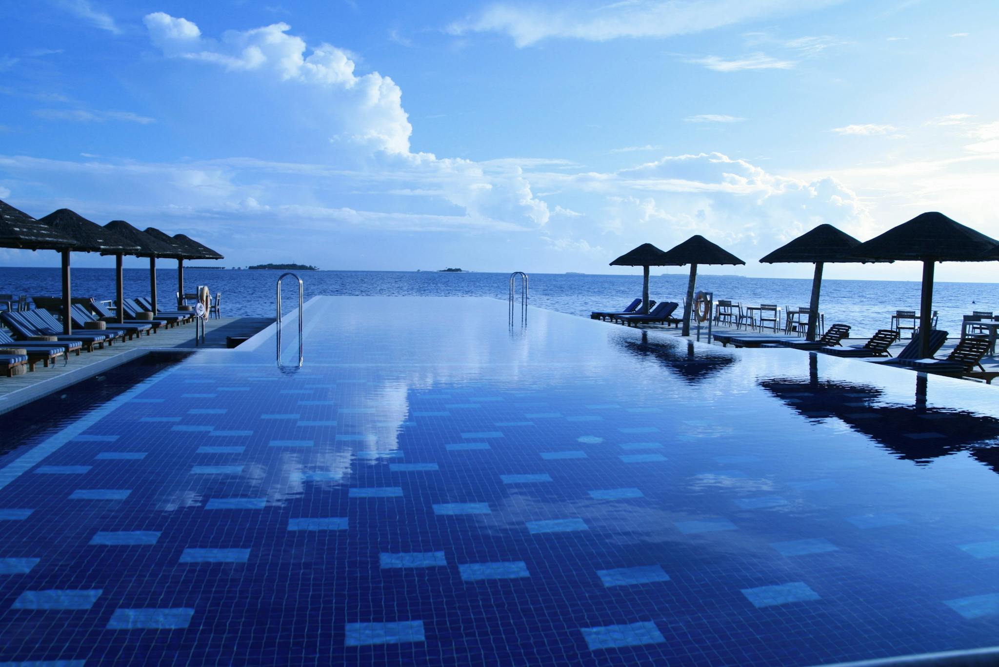 Luxurious infinity pool with ocean view at a tropical resort. Ideal for relaxation.